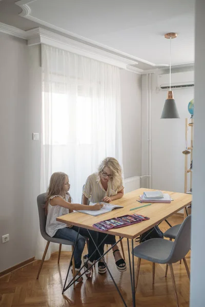 Süße Kaukasische Schulmädchen Lernen Hause Mit Ihrer Mutter lizenzfreie Stockbilder