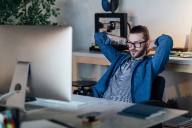 Masaüstü bilgisayar başında çalışırken bir mola yakışıklı genç beyaz serbest meslek.