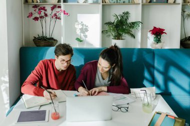 Bir erkek ve bir kız üniversite öğrencilerin birlikte Kütüphanesi'nde eğitim.