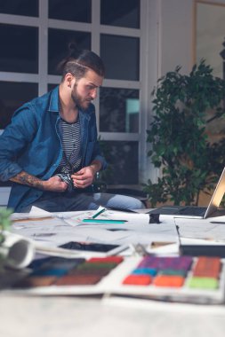 Geceleri bir ofiste çalışan yakışıklı genç Kafkas freelancer tasarımcı.