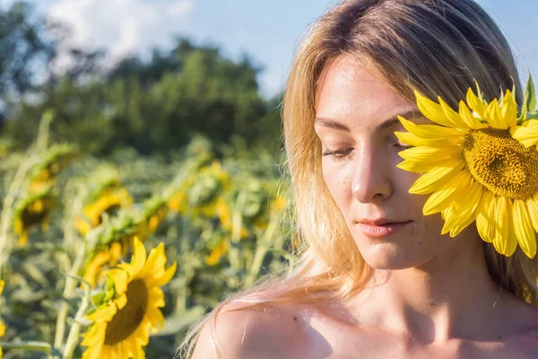 ひまわり畑に立っている美しい金髪の白人女性 ロイヤリティフリーのストック写真