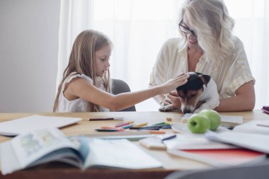 Çok gülümseyen beyaz bir kadın ve onların köpek sarılma şirin kızı evde evde beslenen hayvan.