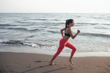 Deniz kenarında kumsalda çalıştıran oldukça beyaz sporcumuz.