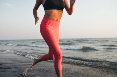 Deniz kenarında kumsalda çalıştıran unrecognisable sporcumuz.