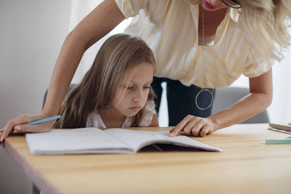 Mutter hilft ihrer Tochter bei den Hausaufgaben — Stockfoto