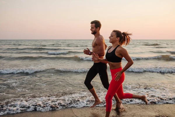 男と女の砂浜ビーチを走る — ストック写真