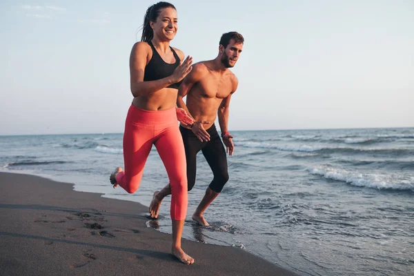 Para biegająca po plaży — Zdjęcie stockowe