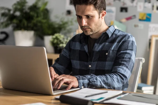 Un hombre escribiendo en el ordenador portátil — Foto de Stock