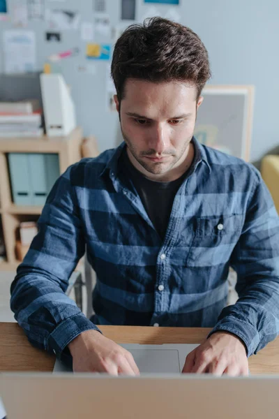 Junger Mann sitzt im Büro — Stockfoto