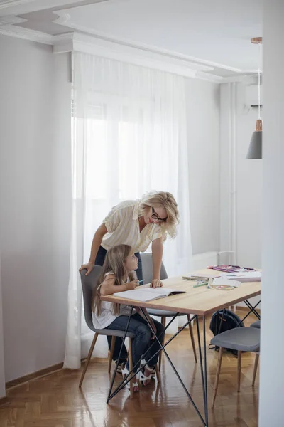 Mor att hjälpa sin dotter att göra en hemläxa — Stockfoto