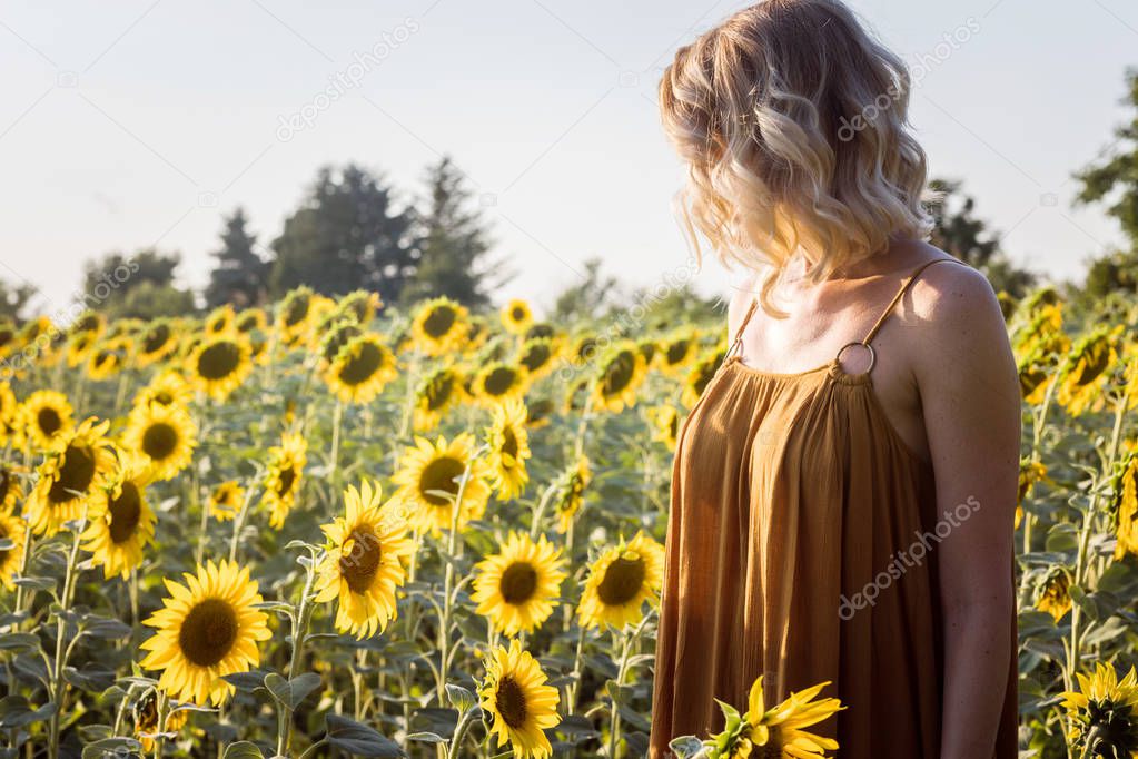 Woman Standing at Sunflower Field