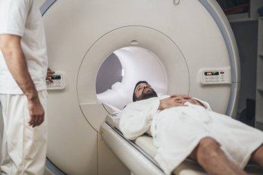 Patient Lying on the CT Scanner Bed clipart