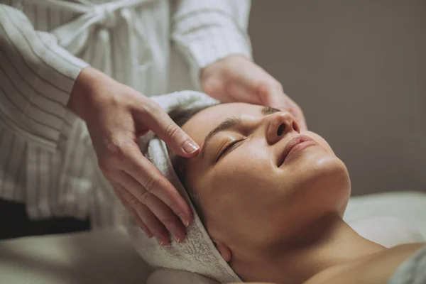 Mujer disfrutando de un masaje facial —  Fotos de Stock