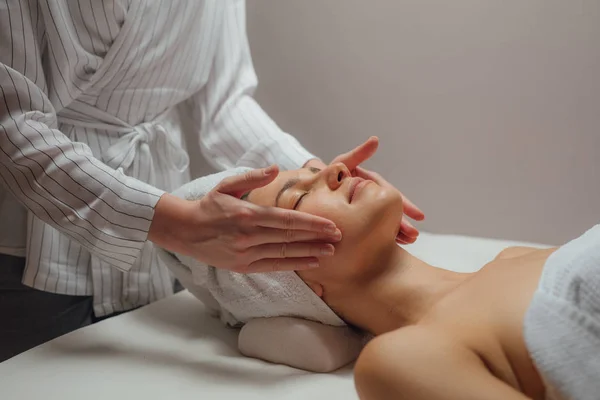 Mulher desfrutando de uma massagem facial — Fotografia de Stock