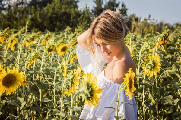 Porträtt av en kvinna i solrosor fält — Stockfoto