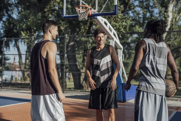 Três homens em uma quadra de basquete — Fotografia de Stock