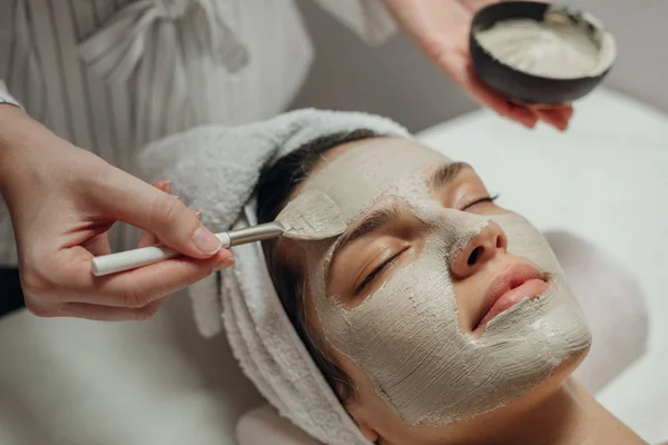 Cosmeotólogo aplicando una máscara facial — Foto de Stock