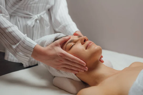 Mulher desfrutando de uma massagem facial — Fotografia de Stock