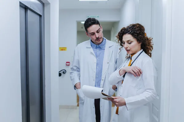 Two Physicians in a Hallway