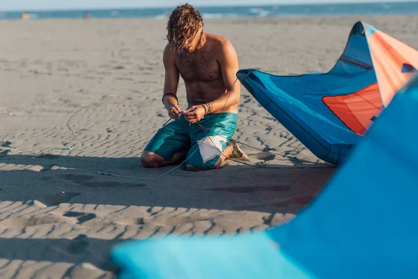 Kitesurfer trabalhando em seu papagaio na praia — Fotografia de Stock