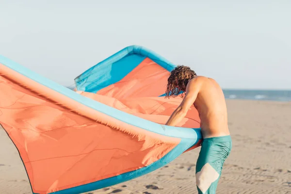 Kitesurfer tenendo il suo aquilone sulla spiaggia di sabbia — Foto Stock