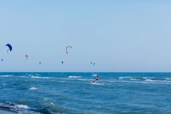 Люди катаются на воздушных змеях на море — стоковое фото