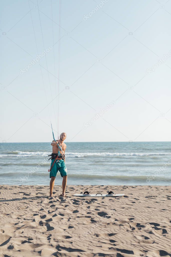 KItesurfer Standing on Sandy Beach