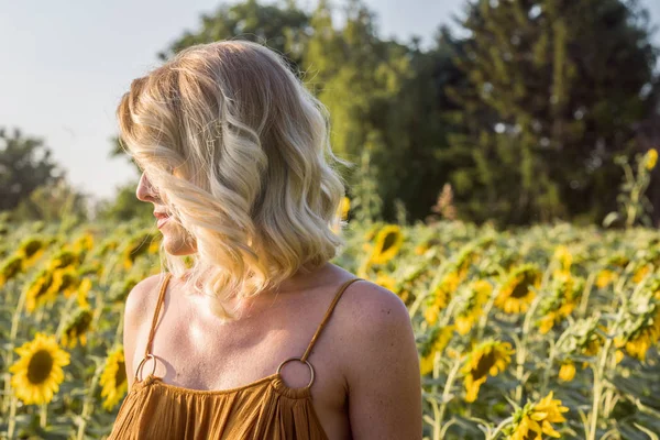 Vrouw bij zonnebloem veld — Stockfoto