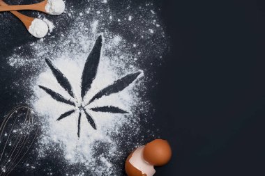 Siyah arka planda undan yapılmış kenevir yaprağı. Esrar pişirme konsepti. Kopyalama alanı olan üst görünüm