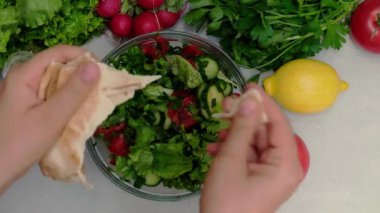 Kadın ellerinin, şişko kaltağa pide ekmeği koyuşunun en üst görüntüsü.