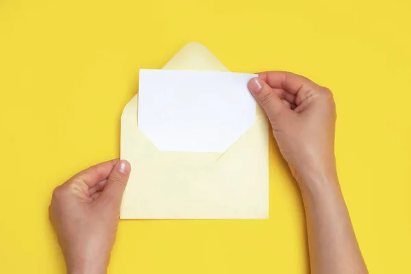 白いカードで開いた封筒を持っている女性の手 — ストック写真