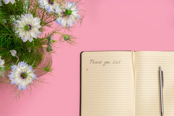 Above view of spring flowers and open gratitude journal