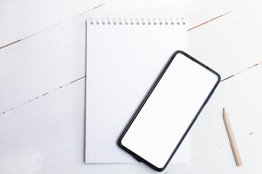 Beyaz ekranlı beyaz ekranlı boş akıllı telefonun beyaz ahşap arka planda üst görünümü