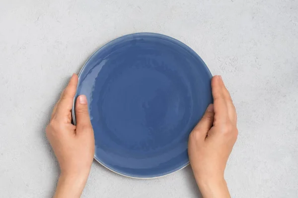 중립적 인 자세로 파란 접시를 들고 있는 여자 손의 윗부분 — 스톡 사진