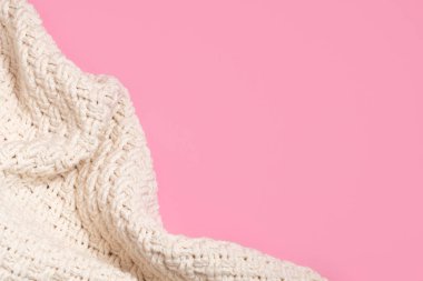 Pastel pembe arkaplan üzerinde örülmüş bej battaniye veya süveter fotokopi alanı ile