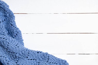 Beyaz ahşap arka planda örülmüş yün battaniye. Kış zamanı için Noel şenliği arka planı