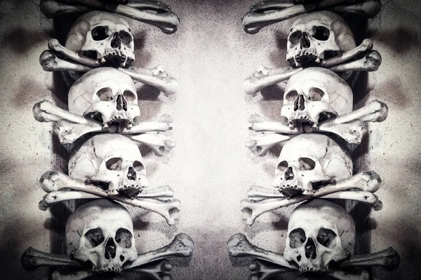 Craniile şi oasele umane se înalţă unul pe altul. Fundal întunecat abstract care simbolizează moartea, răul, întunericul și pirateria . — Fotografie, imagine de stoc