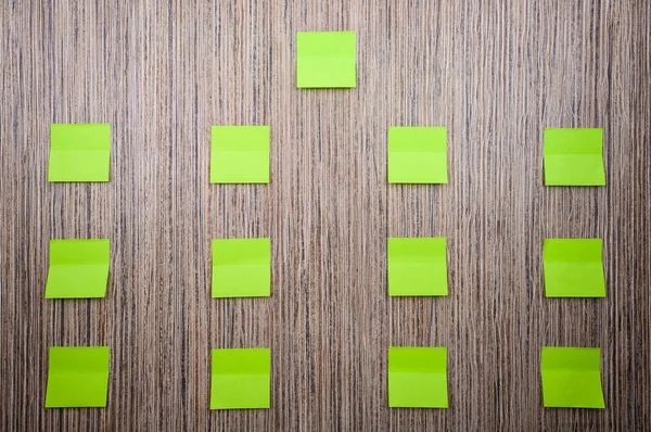 Muitos adesivos verdes para notas sobre um fundo de madeira. Mockup para designer . — Fotografia de Stock