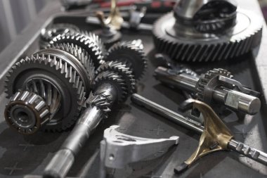 various parts of an automotive manual transmission on a table in a car service. Close up clipart