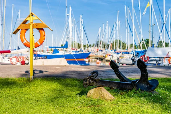 Bóia de salvação e âncora com veleiros embaçados na marina — Fotografia de Stock