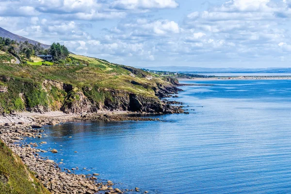 Linha costeira rochosa e montanhas em uma distância com céu azul profundo e mar — Fotografia de Stock