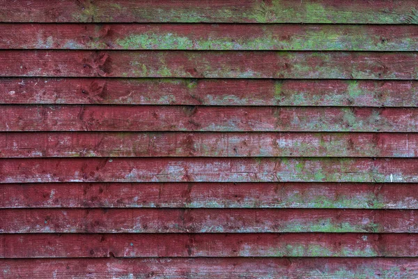 Grunge vecchio recinto di legno rosso con motivi di muschio verde. Struttura e sfondo di alta qualità — Foto Stock