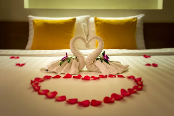 Beyaz iki havlu Swans ve kırmızı gül yaprakları yatakta, balayı dekorasyon