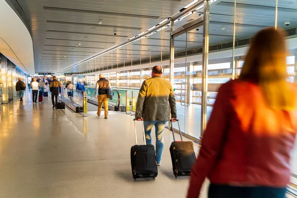 Lufthavn, folk farende for deres flyvninger, lang korridor - Stock-foto