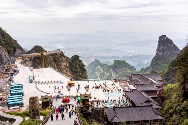 Turister som besöker haven Gate i Tianman Mountain. Hög utsikt över dalen och faciliteter nedan — Stockfoto