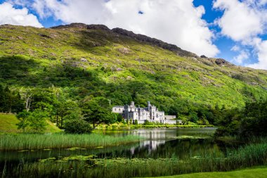 Kylemore Manastırı bir dağın eteklerindegölde yansıması ile. Connemara, İrlanda