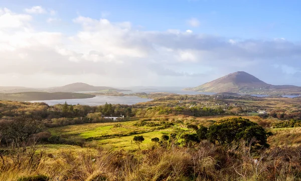 Panoramablick auf Landschaft mit Wiesen, Seen, Bergen und Meer, blauer Himmel mit geschwollenen Wolken — Stockfoto