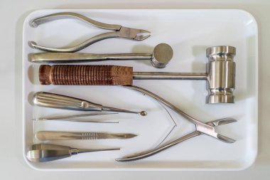 Laboratuvar atölyesindeki beyaz tepsiye yerleştirilmiş cerrahi aletler