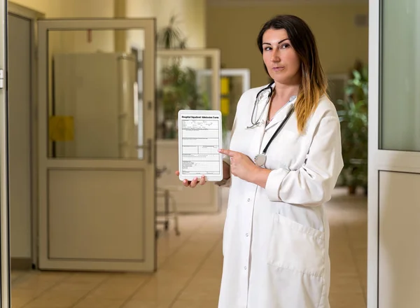 Middle age female doctor in white robe holding and pointing to tablet with Hospital Admission form