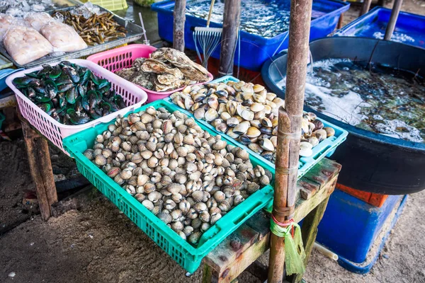 Bazar tailandese con varietà di vongole fresche, cozze e crostacei in cesti e vasche — Foto Stock